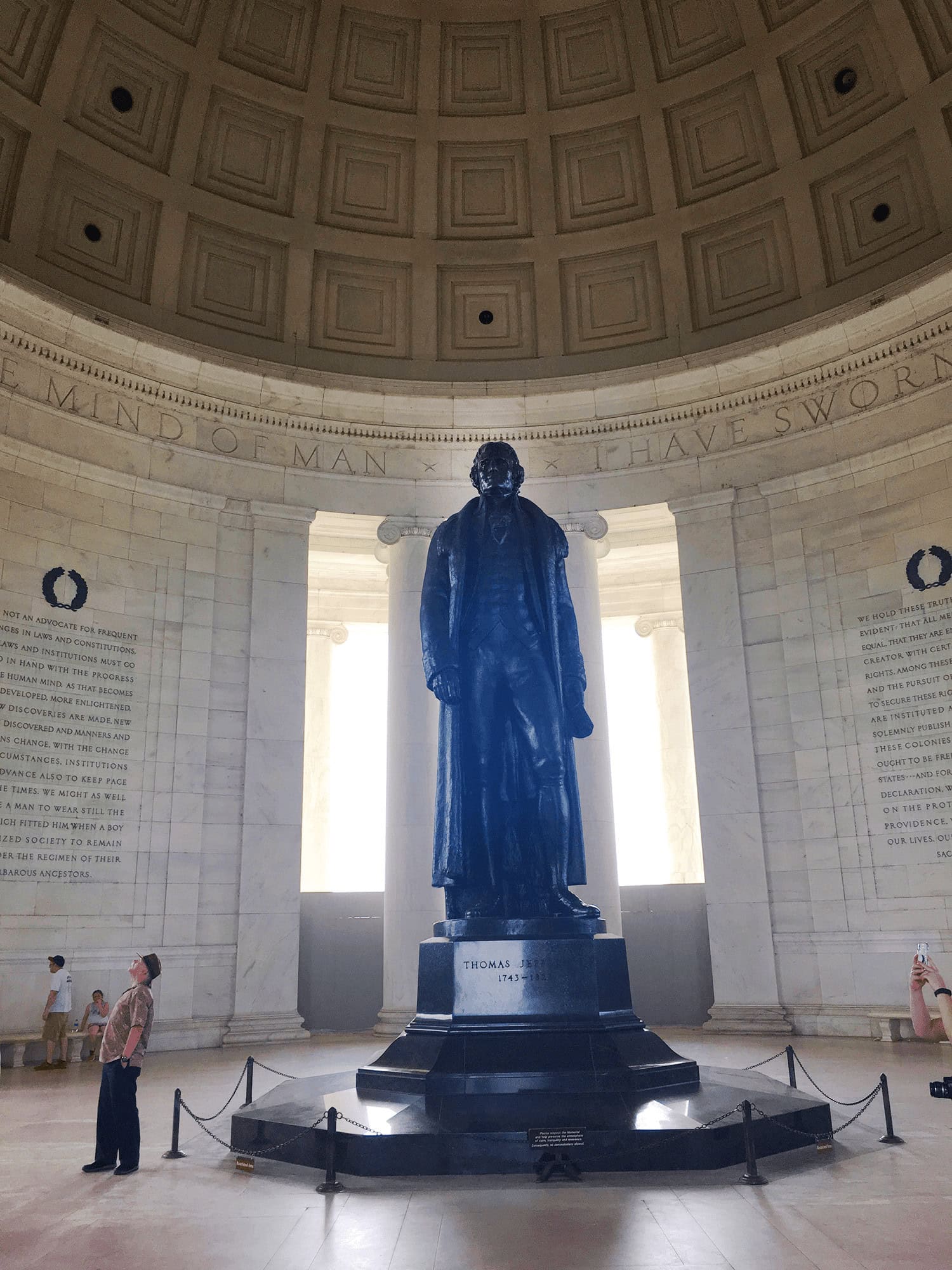 Top 25 Things to Do in Washington, DC: The Best Mostly Free Attractions 14 A 19‑foot bronze statue of Thomas Jefferson standing inside a classical domed rotunda with white marble columns, holding a copy of the Declaration of Independence in his left hand, under soft interior lighting in Washington DC, USA, at the Thomas Jefferson Memorial.