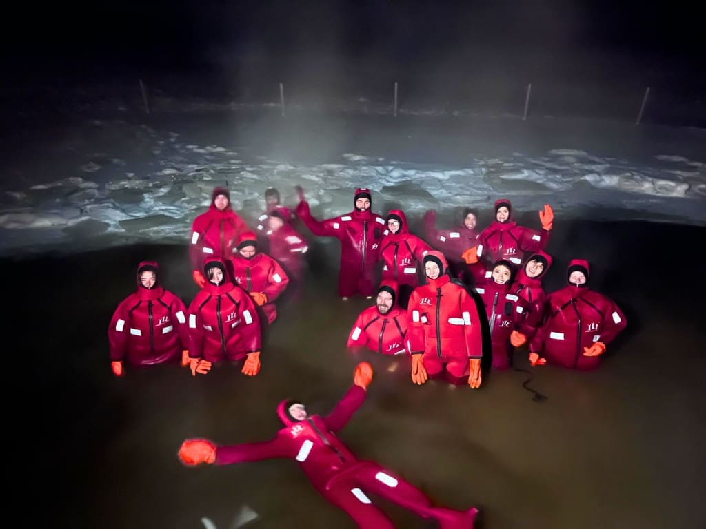 Bumble BFF Review: How I Easily Met My Travel Buddy on This App 12 People ice floating at night in Finland in red suits
