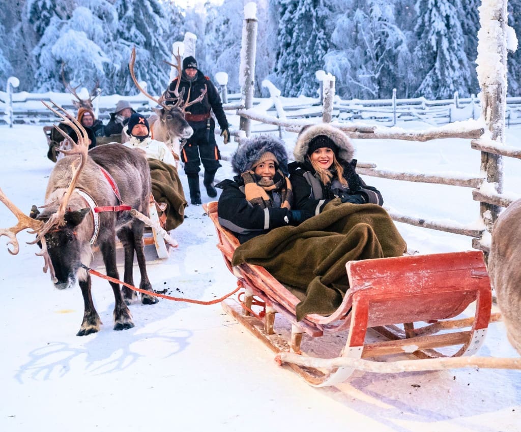 What to Pack for Lapland, Finland: How I Stayed Warm in -20°F 2 Two women taking part in an enchanting Reindeer Sleigh Ride in Finland.
