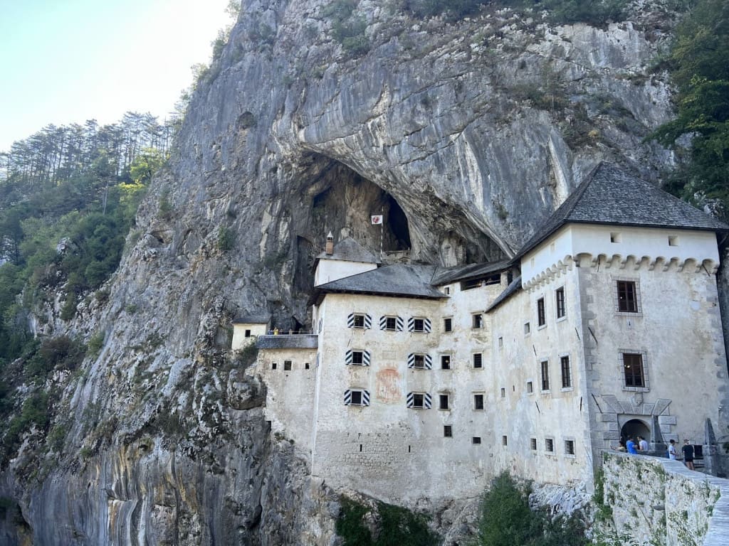18 of the Best Things to Do in Slovenia: Your Ultimate Travel Guide 12 predjama castle trees slovenia